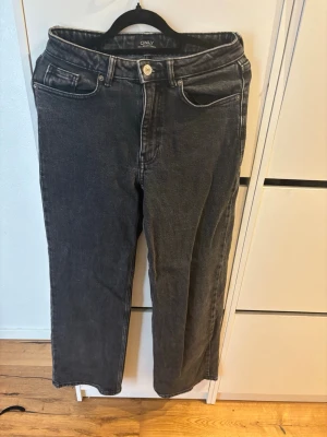 Svarta raka jeans från ONLY - Säljer ett par svarta raka jeans från ONLY med klassisk femficksmodell och hög midja. Jeansen har en avslappnad passform och är tillverkade i ett mjukt denimtyg. Perfekta för en trendig och avslappnad look.