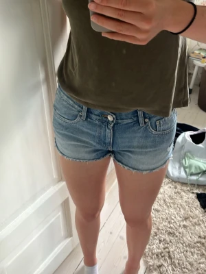 Low waist jeansshorts - Säljer ett par klassiska blå jeansshorts med rå kant och låg midja. De är från Gina tricot och endast använda ett fåtal gånger.