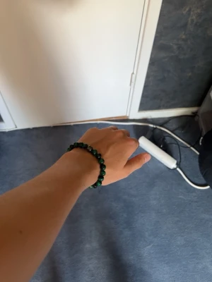 Grönt pärlarmband med stenmönster - Stilrent pärlarmband med gröna pärlor med svarta detaljer från BVALDI , passar för dig som vill ha en mer modern stil. Perfekt skick knappt använda och inget slitage alls. Super enkelt att ta av och på för bandet är elastiskt. 