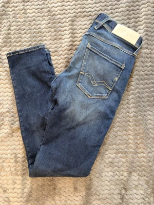 Blå jeans från Replay - Snygga blå jeans från Replay med klassisk femficksdesign och ljusa slitningar på framsidan. Replay anbass, skick 10/10. Size 29.