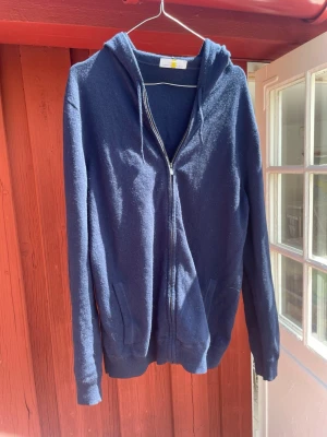 Mörkblå hoodie med dragkedja - Säljer en snygg och mysig 90% wool och 10% Kashmir den är knappt använd och är därför i mycket bra skick. Den är mörkblå. Hör gärna av er vid minsta intresse?