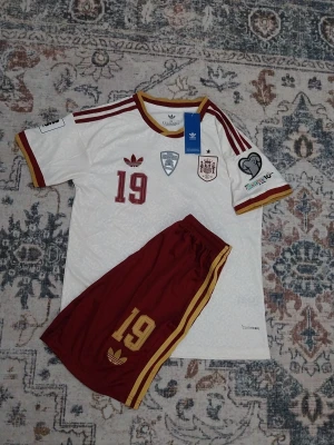 Spanien vm hemmaställ  2026/27 - Spanien vm hemmaställ med vm qualifiers patch och lamine Yamaha nummer 19 i baksidan,barnsize storlek 28.HELT NY MED PRISLAPPAR 