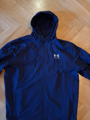 Marinblå vindjacka från Under Armour - Hej säljer min vindjacka ifrån under armour. Den är knappast använd ungefär 3-4 gånger. Nypris 700 