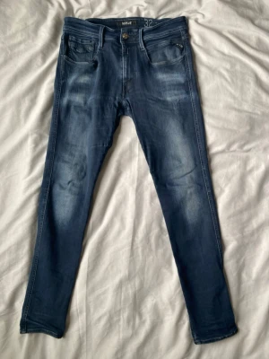 Replay Anbass hyperflex  - Snygga mörkblå slim fit jeans från replay, med riktigt schyssta fades.De är i storleken 32/32. Har en liten lagning i skrevet som syns på sista bilden. Men annars inga andra fel. Hör av dig vid funderingar! 🙌