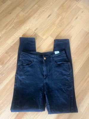 Svarta skinny jeans från Rodebjer - Säljer ett par svarta skinny jeans från Rodebjer, modell Victoria. Jeansen har klassisk femficksdesign, hög midja och är tillverkade i stretchigt material med 98% bomull och 2% elastan. Perfekta för en clean och stilren look.