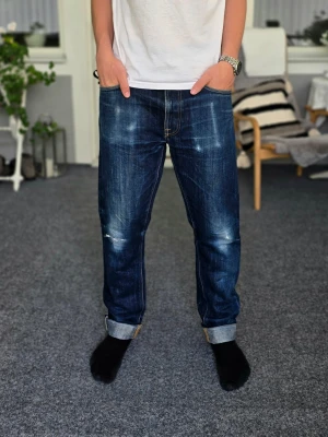 Nudie Selvage jeans Dry Hemp - Säljer mina extremt sällsynta Nudie Dry Hemp Selvedge från den numrerade Indigo Bloodline- kollektionen. Detta är par 152 av endast 178 i hela världen, en av Nudies mest begränsade utgåvor någonsin (Helt annan nivå än Nudies vanliga limited editions som ofta görs i tusentals ex). Byxorna är W34/L34 och lite stora för mig, men jag gillar den baggy passformen så använder jag använder då bälte och viker upp benen. Annars brukar jag ha W32/L32. Skriv om du undrar något och kom gärna med prisförslag!