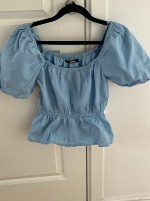Ljusblå puffärm topp BikBok - En super fin topp till sommaren som aldrig kommit till användning, man kan bära den som en off shoulder topp men också över axlarna🌸  Storlek XS Aldrig använd   Skickar gärna fler bilder eller svarar på frågar🤗