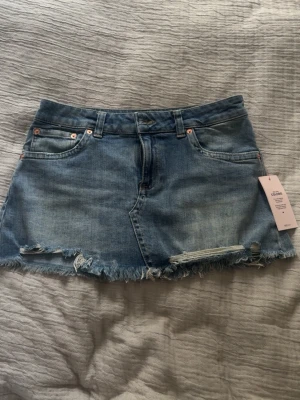 Blå jeanskjol - Säljer en blå jeanskjol från Nelly! Den är i strorlek 36. Den är även oanvänd.