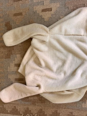 Krämvit teddyjacka från Jack & Jones - Mysig teddyjacka i krämvit färg från Weekday. Jackan har en fluffig, fårullsliknande yta och är helfodrad med ljus innerfoder. Rak passform och långa ärmar. Perfekt för att hålla värmen under kyliga dagar.