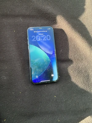 Blå iPhone 12 Pro med trippelkamera - Snygg blå iPhone 12 Pro med stilren design och platt kant. Baksidan är i glas och har tre kameror samt Apple-loggan. Framsidan har en stor skärm med tunna ramar. Perfekt för dig som gillar modern teknik och vill ha en kraftfull mobil.