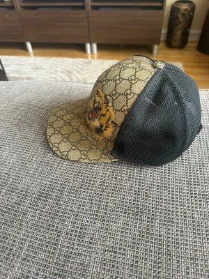 Gucci keps med tigertryck - Säljer min gucci keps som inte kommer till någon användning den är fräsch och snygg till sommaren. Kepsen är äkta och köptes ungefär 2021, hör av er för mer information. 