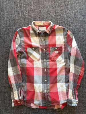 Rutig röd skjorta från Denim & Supply - Klassisk rutig skjorta från Ralph Lauren Denim & Supply i rött, vitt och grått. Skjortan har två bröstfickor med knapp, knappar framtill och lång ärm. Tillverkad i mjuk bomull och har en avslappnad passform. Perfekt för en casual look.