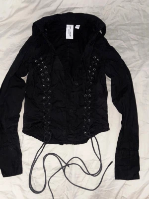 Alt alternativ goth gothic emo svart korsettskjorta - Helt ny men sydd litee ojämn i botten av baksidan, snug flattering fit! Sleeve length från axeln till ärmen är ca 60cm, waist ca 32cm. 100% bomull