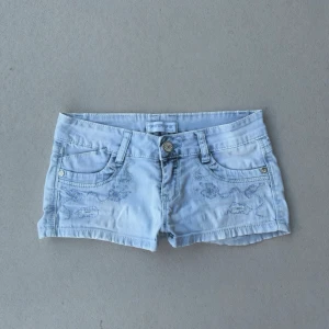 y2k lågmidjade ljusblå jeansshorts  - sötaste jeansshortsen 🩵 så fina detaljer och tvätt, väldigt unika från 2000talet  ♡︎passar xs - xxs  ♡︎midjan mäter 33 (lite stretchiga) ♡︎längd fram 18 ♡︎längd bak 23   ♡︎fint skick, slitningarna är original design  