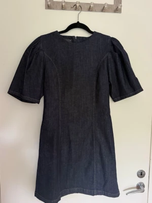 Mörkblå jeansklänning från Zara - Trendig mörkblå jeansklänning från Zara. Jätte fin i storlek L men skulle säga att den är mer en M, helt ny med prislappen kvar 
