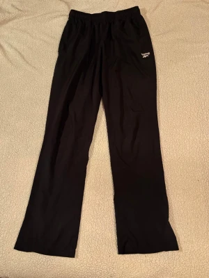 Reebok Woven träningsbyxor - Reebok Woven pants i storlek S (herrstorlek). I mycket fint skick. Byxorna är hel svarta, inga fläckar eller andra defekter.