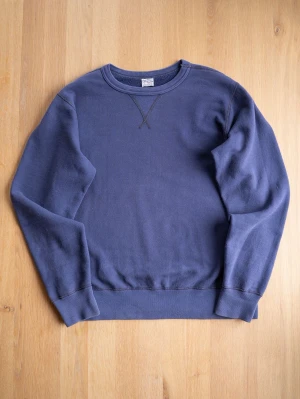 Buzz Rickson Blå Loopwheel Sweatshirt, size L - Japanska Buzz Rickson Sweatshirt med fin patina.  Klassisk design med dekorativt V-stygn vid halsen. Tillverkad i mjuk bomull som känns skön mot huden. Perfekt för en avslappnad och stilren look.