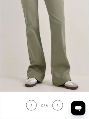 Olivgröna bootcut byxor - Snygga olivgröna byxor med bootcut-modell och hög midja. Byxorna har en avslappnad passform och är tillverkade i ett mjukt bomullsmaterial. Perfekta för dig som gillar en retroinspirerad look.