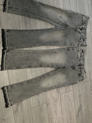 Gråa raka jeans med råa kanter - Skriv till mig om ni bara vill ha en  Säljer ett par gråa jeans med rak passform och snyggt tvättad look. Jeansen har fem fickor och råa, fransiga benslut för en trendig vibe. Perfekta för dig som gillar en avslappnad och cool stil. Materialet är klassisk denim.