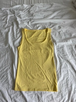 Gul ärmlös linnetopp - Snygg gul linnetopp med rund halsringning och ärmlös design. Perfekt för varma dagar och enkel att matcha med jeans eller kjol. Tillverkad i mjuk bomull som känns skön mot huden. Toppen är från Zara i storlek S! Packas och Postas säkert!💓