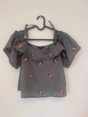 New look - En off shoulder topp från New Look i strl 10 vilket ska motsvara strl 38. Axelband och ärmar off shoulder. Ställbara axelband. Broderade blomdetaljer.   Sparsamt använd och i gott skick. Hittar ingenting att anmärka på.