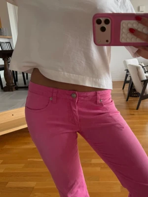 Lågmidjade bootcut rosa jeans  - Super snygga jeans som är lite för korta för mig. Innerbenslängd: 75cm Midjemått tvärs över: 39 cm. Passar perfekt för mig som brukar ha 36 i jeans 