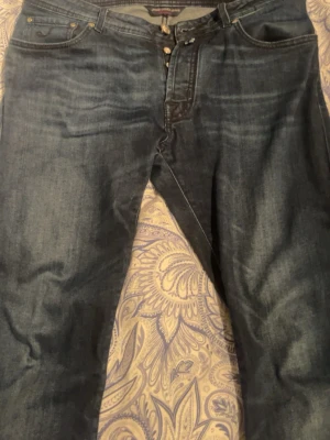 Mörkblå jeans med relaxed fit, jacob cohen - Säljer ett par mörkblå jeans med relaxed fit och klassisk femficksmodell. Jeansen har knäppning fram och subtila slitningar för en avslappnad look. Passar perfekt till en casual stil och är tillverkade i denim med skön stretch.