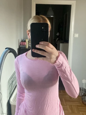 Ljusrosa långärmad topp - Säljer en ljusrosa långärmad topp med rund halsringning. Toppen har en slim passform och är tillverkad i ett mjukt material som sitter skönt mot kroppen. Perfekt för dig som gillar en enkel och clean look.