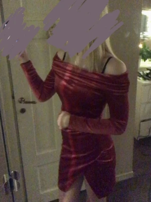 Röd sammetsoffshoulder klänning från Bubble Room - Säljer en snygg röd kort klänning i sammet med offshoulder-design och långa ärmar. Klänningen har en kroppsnära passform och en liten slits framtill. Från Bubble Room