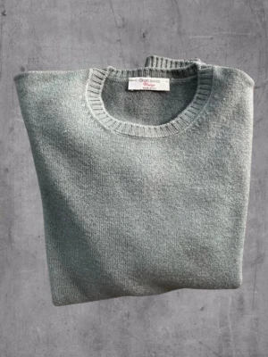 Grå stickad tröja Gran Sasso - Klassisk grå stickad tröja från Gran Sasso Vintage, tillverkad i Italien. Tröjan har rund halsringning och ribbade muddar vid hals, ärmslut och nederkant. Perfekt basplagg för lager på lager och enkel att matcha.