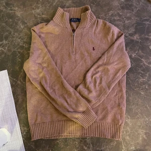 Tröja från Polo Ralph Lauren - Säljer en stilren tröja från Polo Ralph Lauren med dragkedja vid halsen. Tröjan har långa ärmar och ribbade muddar vid ärmslut och nederkant. Perfekt för en avslappnad och snygg look.(Ny pris 2800kr)