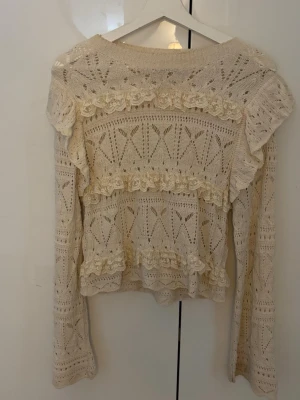 Beige stickad tröja med volanger - Beig stickad tröja med långa med volang. Använd få tals gånger💕