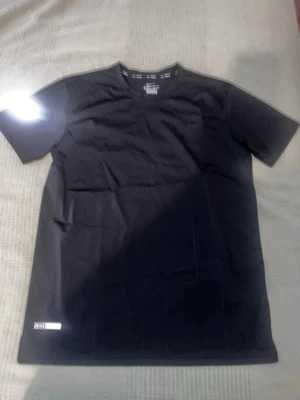 Svart t-shirt från Nike - En stilren svart t-shirt från nike med klassisk rund hals och korta ärmar. Tillverkad i mjuk bomull för en bekväm känsla. Diskret logga nertill på framsidan ger en clean look som passar till allt. BRA FÖR GYM!