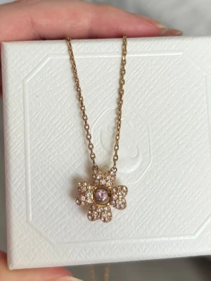 Swarovski Idyllia Necklace - Material: jewelry metal. Jewelry color: rose gold Stones: clear and pink crystals. Chain length: 38-45 cm (adjustable). Pendant size: 1.5 x 1.4 cm
