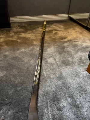 Svart och gul hockeyklubba Bauer porto R - Säljer en guldig porto R från Bauer i 50 flex lite förlängd med ett blad som är p92. Har använts på en match och 3 träningar så är i gott skick
