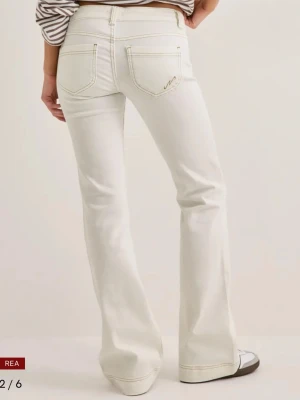 Vita bootcut jeans från Nelly - Säljer ett par vita bootcut jeans från Nelly med klassisk femficksmodell och ljusa kontrastsömmar. Jeansen har super låg midja och utsvängda ben. Byxorna var ej använda så mycket kanske max 2 gånger.