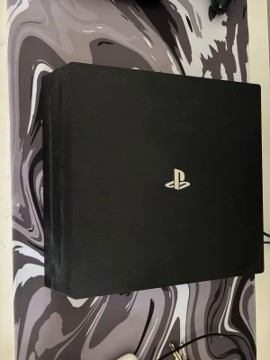 PlayStation 4 Pro med två kontroller - Säljer en svart PlayStation 4 Pro från Sony med två matchande svarta DualShock 4-kontroller. Konsolen har en stilren, kantig design och är tillverkad i plast. Perfekt för gaming och filmkvällar med vänner. En av kontrollerna måste byta batteri så priset kan diskuteras och 3 valfria spel. Det kommer med original kartong 