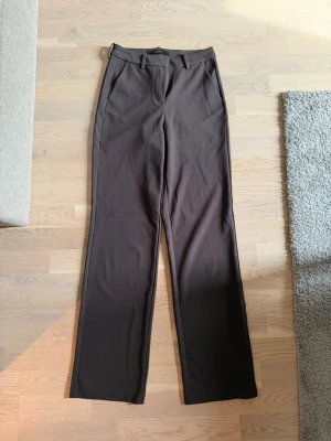 Kostymbyxor  - Bruna kostymbyxor från Vero Moda med raka ben och högre midja samt lite stretch. Säljer på grund av kommer inte till användning längre. Använd endast en gång 