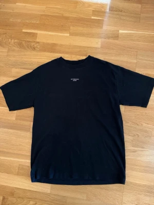 Svart t-shirt från Drôle de Monsieur - Svart äkta t-shirt från Drôle de Monsieur. Klassisk rund hals och korta ärmar, perfekt för en clean och stilren look. T-shirten är oanvänd då den är för stor för mig tyvärr.