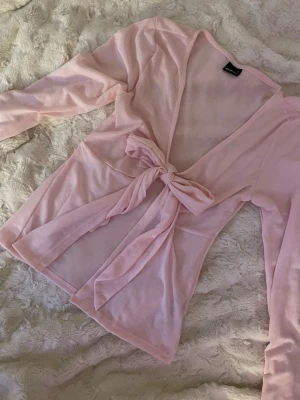Ljusrosa omlottopp från Gina Tricot - Supersöt ljusrosa topp från Gina Tricot med lång ärm och knyt framtill. Använd Max 2ggr och superfint skick! 