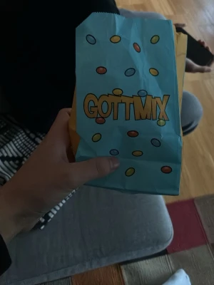 Maison marginella godispåse - Säljer en klassisk Gottmix godispåse i papper med blå och gul färg samt färgglada godisillustrationer. Perfekt för dig som vill ha en retro känsla till godisstunden eller bara gillar coola påsar. Påsen är lätt och smidig att bära med sig.