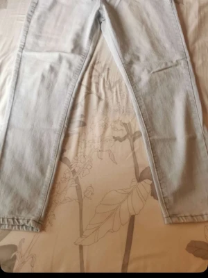 Ljusblå raka jeans - Säljer ett par ljusblå jeans med rak passform och klassisk femficksdesign. Jeansen har normal midja och är tillverkade i denim. Perfekta för en avslappnad och stilren look.