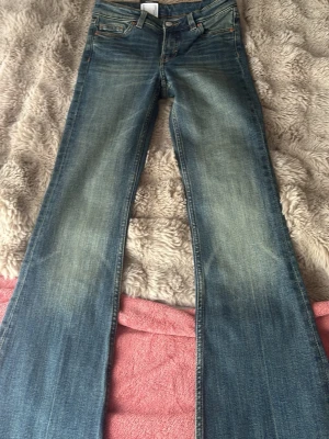 Low Waist bootcut/ flared jeans - Säljer ett par blå bootcut jeans från Monki med klassisk femficksmodell och snygga med ett topp över. De är sprillans nya och har prisettikett på. De är i storlek 32 men passar även de i storlek 34 eftersom den är ganska stretchig. De är från Monki.