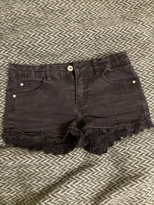 Snygga shorts - Lågmidjade svarta shorts med spetskant. Storlek 164 men passar som xs/s