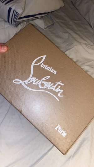 Röda skor  - Snygga röda sneakers från hm  med ikoniska nitar på tån och sidorna. Skorna har en helröd design, inklusive sula och snören, samt en mix av mocka och lädermaterial. Perfekta för dig som vill sticka ut med en lyxig och edgy stil.