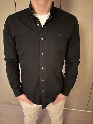 Svart skjorta från Ralph Lauren - Säljer denna snygga Ralph lauren skjortan, Str S, Inga defekter väldigt bra skick, priset går att diskutera vid snabb affär, skriv dm vid frågor.