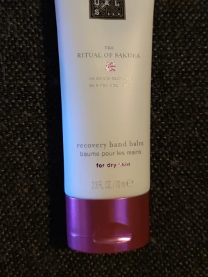 Rituals Sakura handbalsam 70 ml - Rituals The Ritual of Sakura recovery hand balm är en återfuktande handkräm för torr hud. Tuben är vit med rosa detaljer och rymmer 70 ml. Innehåller bland annat sheasmör, risextrakt och körsbärsblomma. Perfekt för att vårda och mjukgöra händerna.
