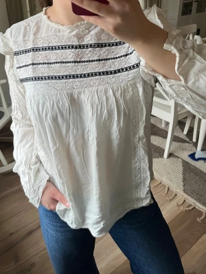 Vit blus - Säljer en vit boho-inspirerad blus med spetsdetaljer i svart. Passa absolut M också, samt  ska absolut strykas innan jag skickar den;)
