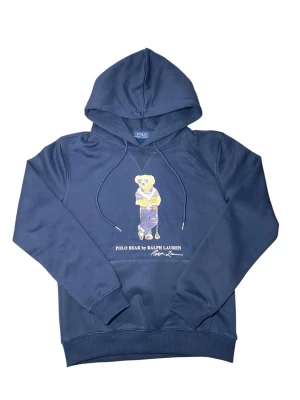 Mörkblå hoodie Polo Bear Ralph Lauren - Mörkblå hoodie från Ralph Lauren med den ikoniska Polo Bear-trycket på bröstet. Hoodien har dragsko i huvan, ribbade muddar och en klassisk känguruficka. Tillverkad i mjukt bomullsmaterial som är skönt att bära. Perfekt för en avslappnad och stilren look.