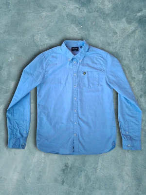 Lyle & Scott skjorta - Säljer en ljusblå Lyle & Scott tröja. Tröjan är 100% bomull och den ljusblåa färgen gör att den är perfekt nu när sommaren närmar sig! Tröjan har den gula Lyle & Scott fågeln på vänstra bröstet och är I storlek 15-16 år som motsvara ca xs/s. Modellen I bild är 173cm lång Skjortan har inga synliga defekter. Hör gärna av er om ni har några funderingar!😁 Pris kan diskuteras vid snabb affär👍